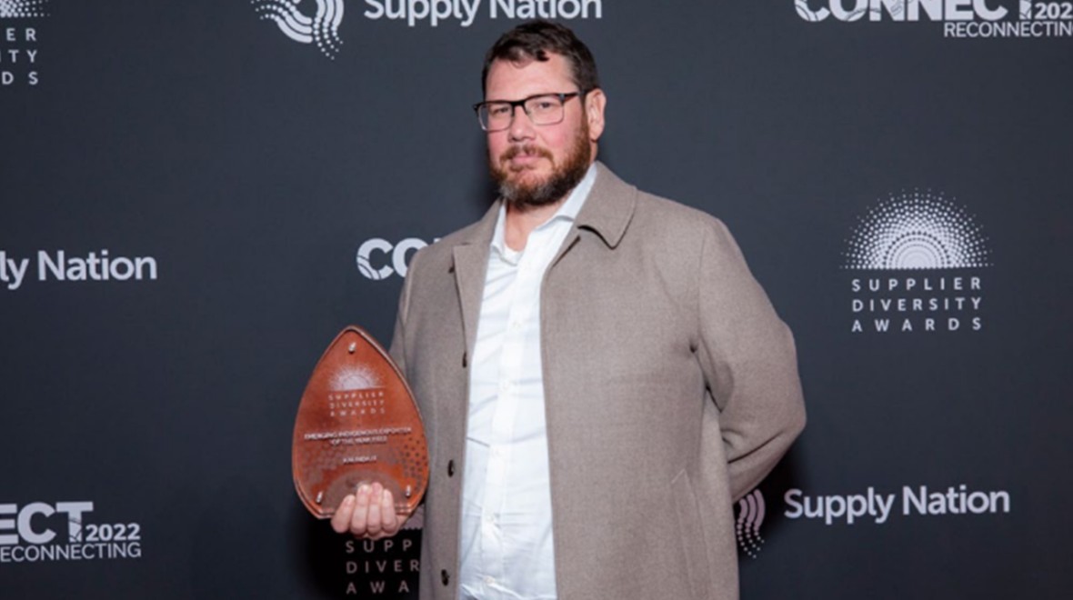 The image features Kalinda IT CEO, Michael Dickerson, holding the prestigious 2022 Nation Indigenous Exporter of the Year Award. In the photograph, Michael Dickerson is shown proudly with the award, celebrating the company's achievement.